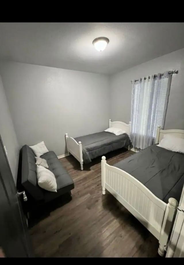 bedroom with dark wood-type flooring