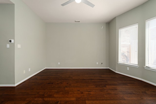 empty room with plenty of natural light, dark hardwood / wood-style flooring, and ceiling fan