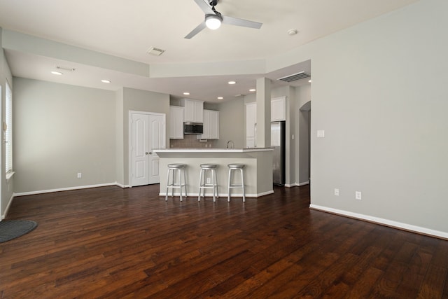 unfurnished living room featuring dark hardwood / wood-style floors, sink, and ceiling fan