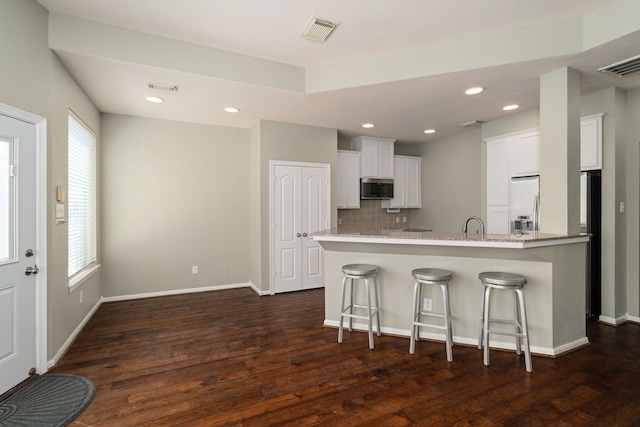 kitchen featuring white cabinets, stainless steel appliances, kitchen peninsula, and a wealth of natural light