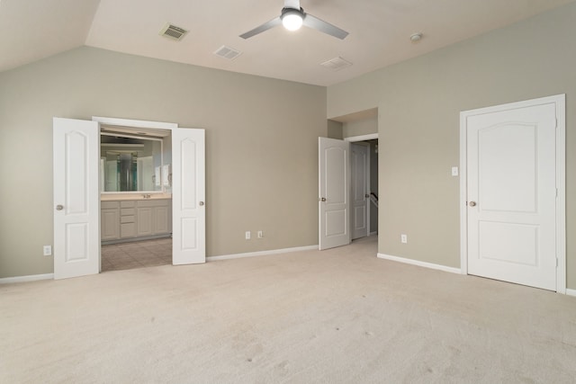 unfurnished bedroom with light carpet, lofted ceiling, connected bathroom, and ceiling fan