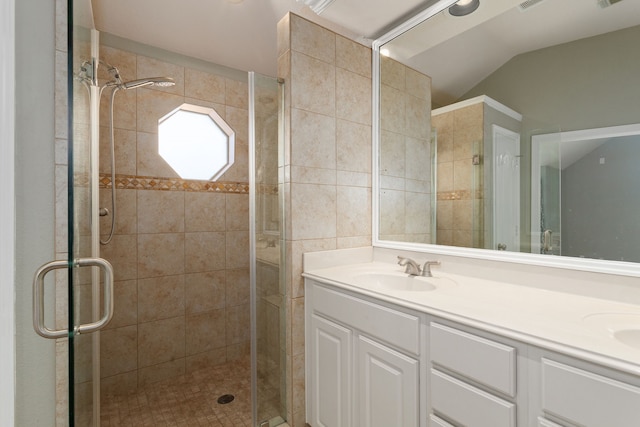 bathroom with vanity, lofted ceiling, and a shower with door