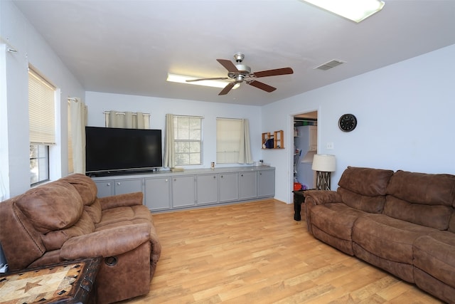 living room featuring ceiling fan and light hardwood / wood-style floors