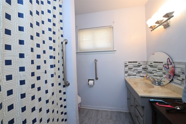 bathroom with vanity, backsplash, toilet, and hardwood / wood-style flooring