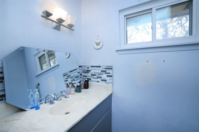 bathroom featuring tasteful backsplash and vanity