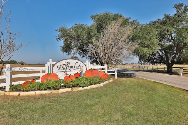 community / neighborhood sign featuring a yard and a rural view