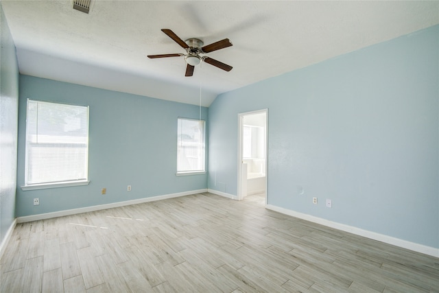 unfurnished room featuring ceiling fan, light hardwood / wood-style flooring, lofted ceiling, and a healthy amount of sunlight