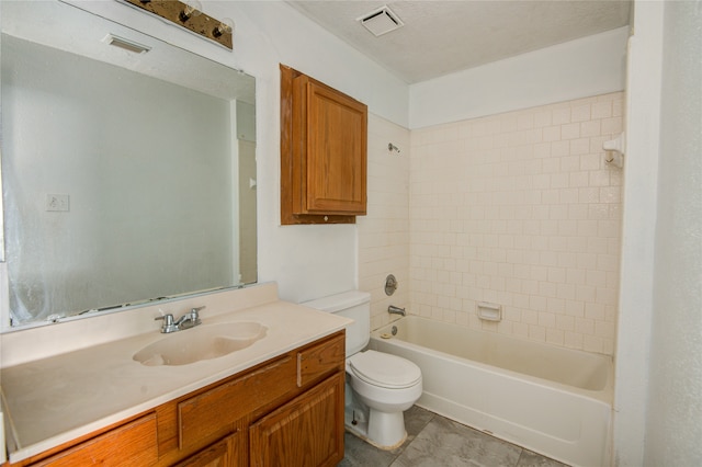 full bathroom featuring tiled shower / bath, vanity, toilet, and a textured ceiling