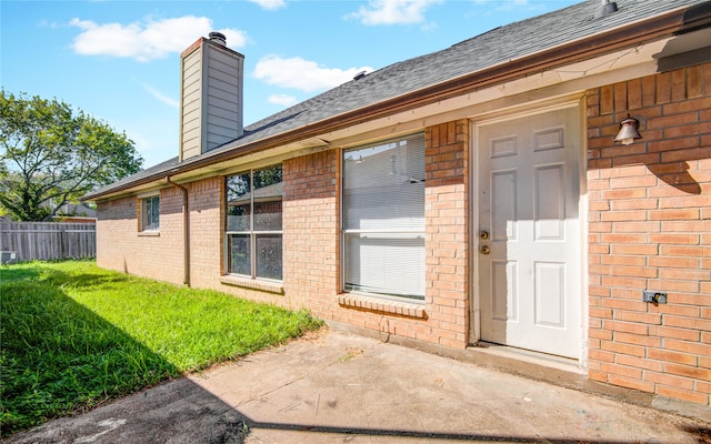 view of exterior entry with a lawn