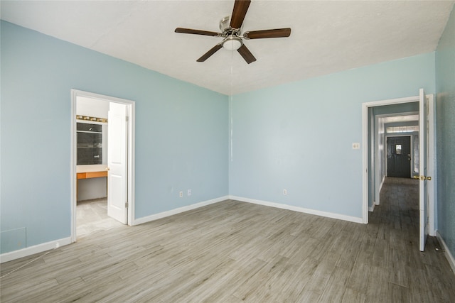 unfurnished bedroom featuring ensuite bathroom, light hardwood / wood-style flooring, and ceiling fan