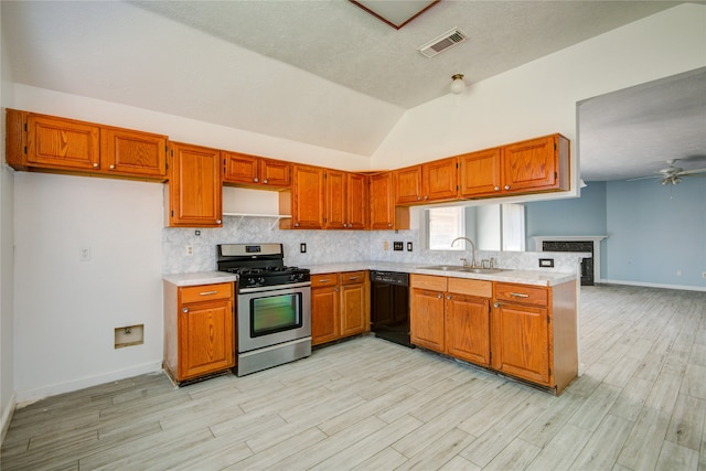 kitchen with stainless steel gas range oven, ceiling fan, vaulted ceiling, sink, and dishwasher