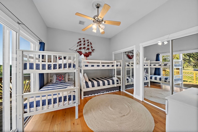 bedroom featuring wood-type flooring, multiple windows, and ceiling fan