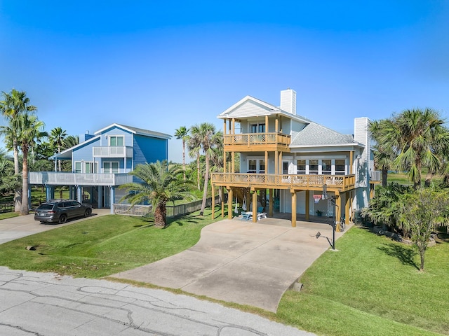 raised beach house with a carport, a balcony, and a front yard