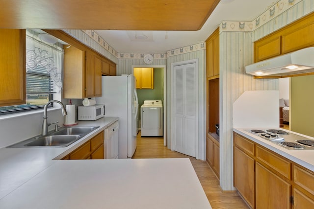 266 Water Ridge Dr, Livingston, TX 77351 - kitchen featuring washer / clothes dryer, white appliances, under cabinet range hood, a sink, and light countertops