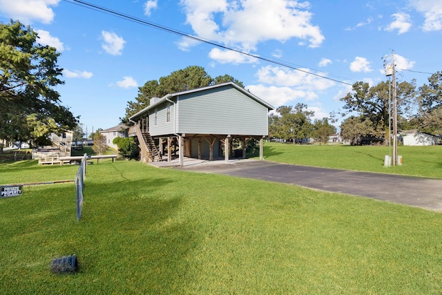 view of side of home featuring a carport and a lawn