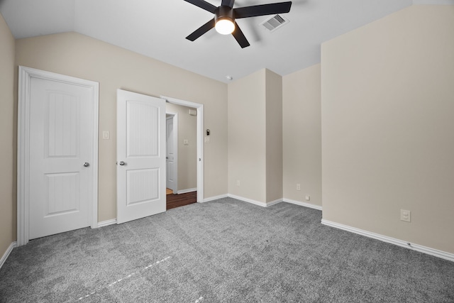 unfurnished bedroom with ceiling fan, dark colored carpet, and vaulted ceiling