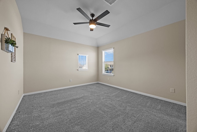 empty room with dark colored carpet and ceiling fan