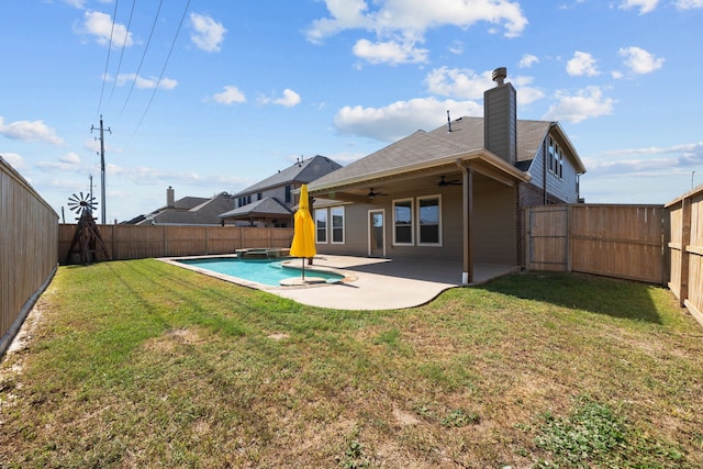 rear view of house featuring ceiling fan, a yard, and a patio area