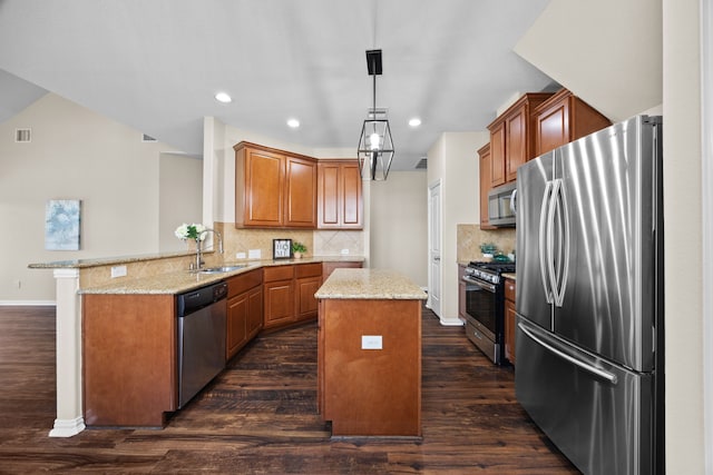 kitchen with kitchen peninsula, dark hardwood / wood-style floors, appliances with stainless steel finishes, and a kitchen island