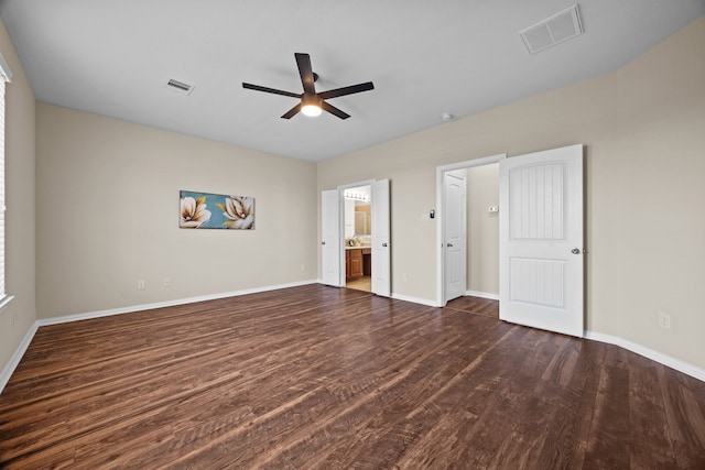 unfurnished bedroom featuring ceiling fan, dark wood-type flooring, and ensuite bathroom