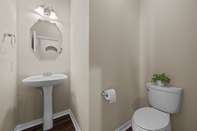 bathroom featuring wood-type flooring, sink, and toilet