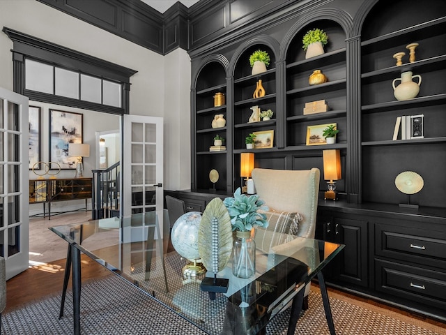 office space with built in shelves and hardwood / wood-style flooring