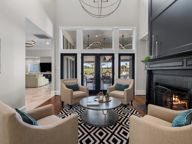 living room with wood-type flooring, crown molding, and a high ceiling