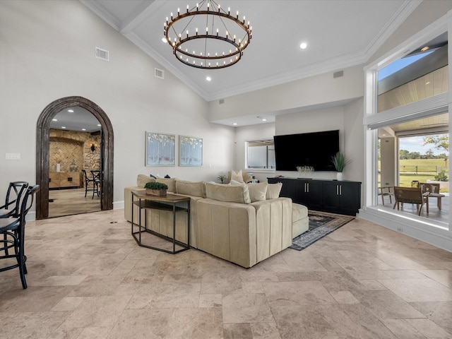 living room featuring a chandelier, a high ceiling, and ornamental molding