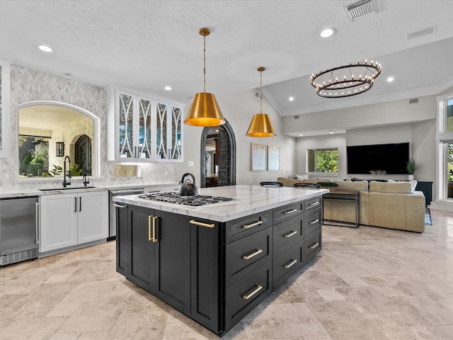 kitchen featuring white cabinetry, a wealth of natural light, sink, and decorative light fixtures