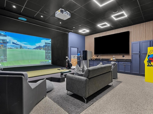 carpeted cinema with a paneled ceiling and golf simulator