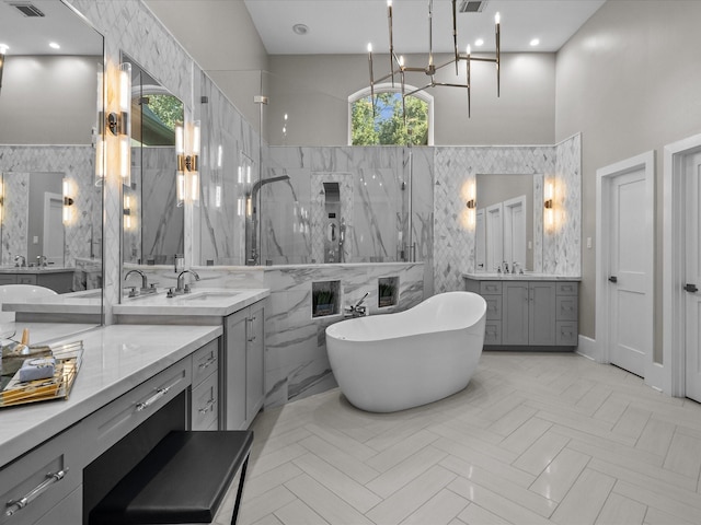 bathroom featuring vanity, plus walk in shower, tile walls, and an inviting chandelier