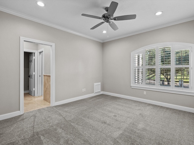 carpeted spare room featuring ceiling fan and crown molding