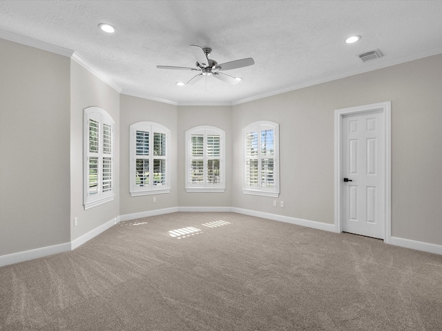 empty room featuring a textured ceiling, carpet floors, ceiling fan, and ornamental molding