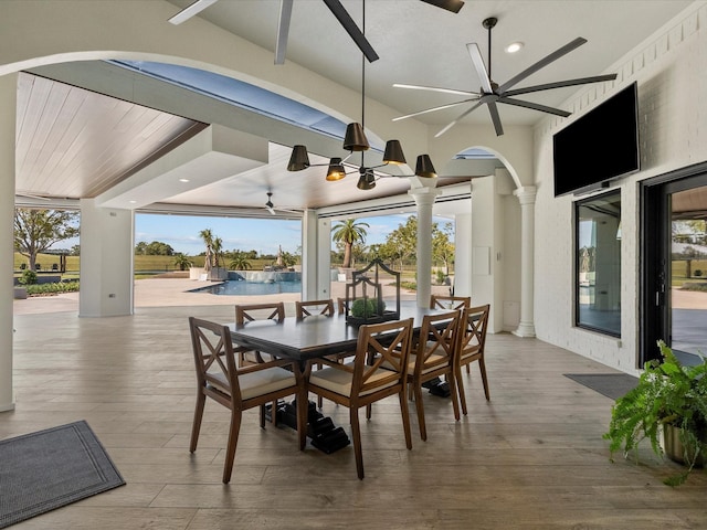 dining area featuring ceiling fan, wood-type flooring, and ornate columns