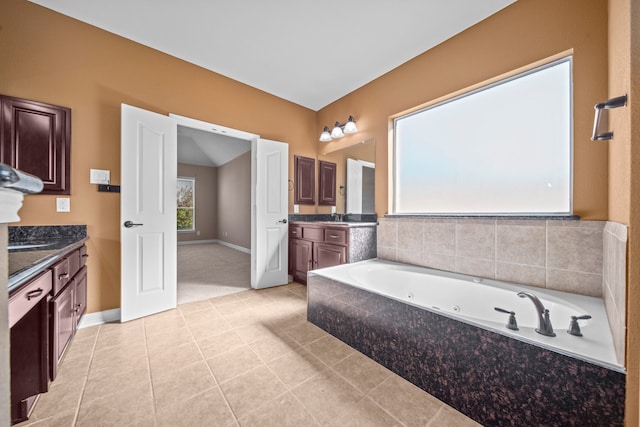 bathroom with vanity, tile patterned floors, and tiled bath