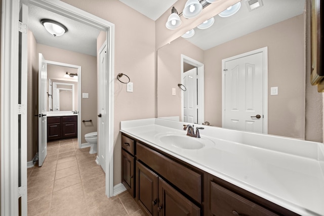 bathroom featuring vanity, toilet, and tile patterned flooring