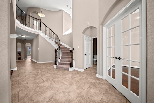 foyer entrance with french doors and a towering ceiling