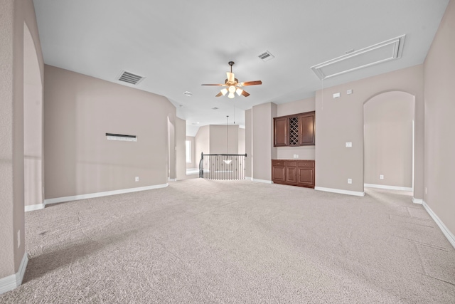 unfurnished living room with light colored carpet and ceiling fan