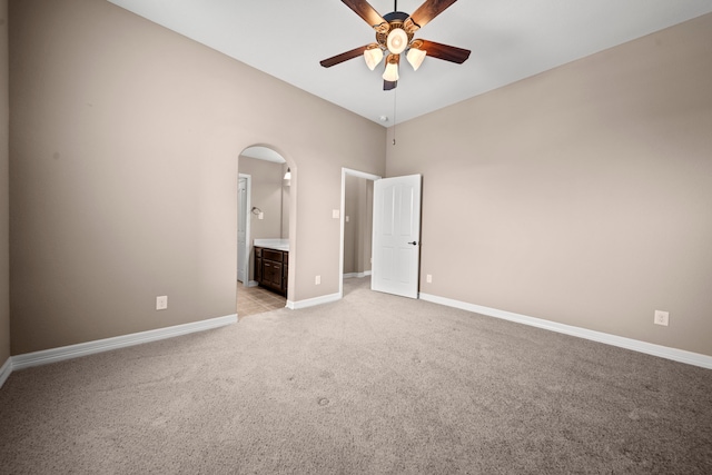 unfurnished bedroom featuring light carpet, ensuite bathroom, and ceiling fan