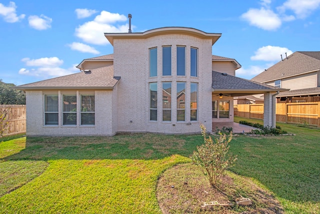 back of property with a yard and a patio