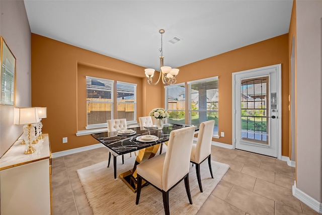 tiled dining room with an inviting chandelier and plenty of natural light