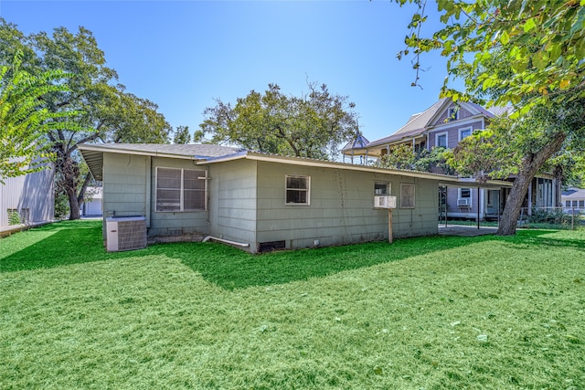 back of property with a yard and central AC unit