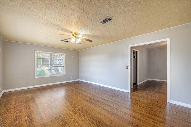 empty room with dark wood-type flooring, crown molding, and ceiling fan