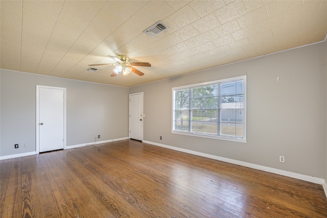 unfurnished room with ornamental molding, dark wood-type flooring, and ceiling fan