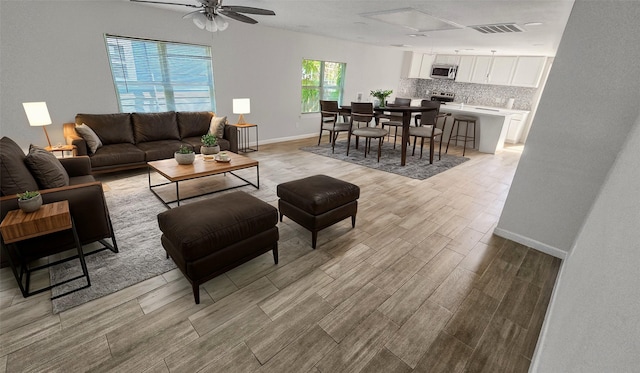 7120 Ave O, Houston, TX 77011 - living area featuring visible vents, light wood-style floors, ceiling fan, and baseboards