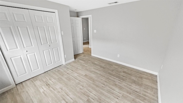 7120 Ave O, Houston, TX 77011 - unfurnished bedroom with visible vents, baseboards, light wood finished floors, and a closet
