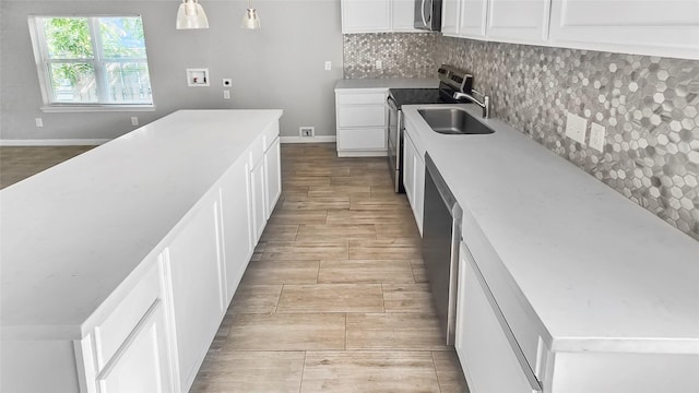 7120 Ave O, Houston, TX 77011 - kitchen featuring white cabinets, stainless steel appliances, a sink, and tasteful backsplash