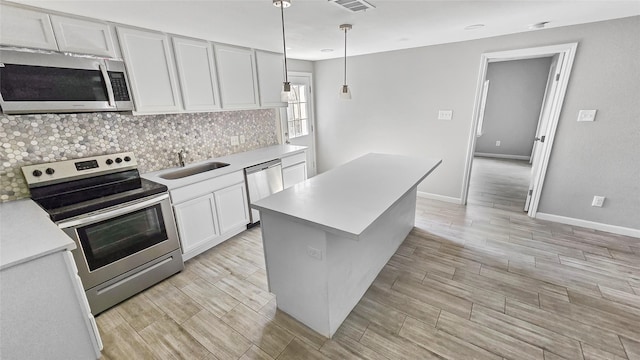 7120 Ave O, Houston, TX 77011 - kitchen featuring backsplash, a sink, light countertops, stainless steel appliances, and white cabinetry