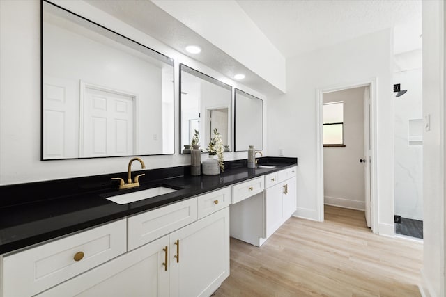 bathroom featuring a shower, vanity, wood-type flooring, and a textured ceiling