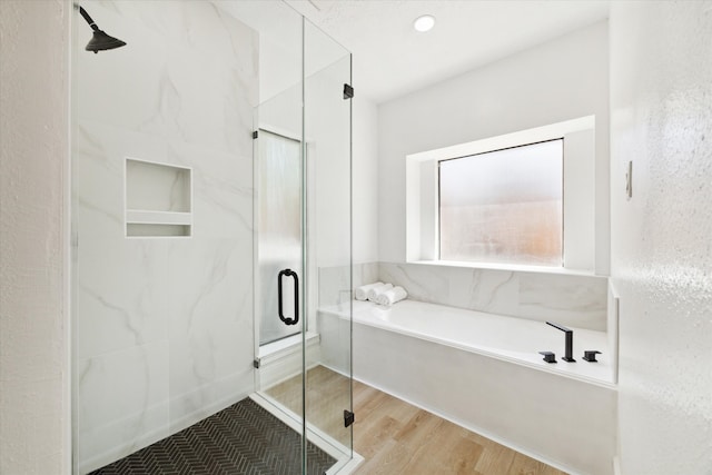 bathroom featuring separate shower and tub and hardwood / wood-style flooring